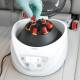 Globe Scientific GCC-P Portable Clinical Centrifuge - A Gloved hand placing a Test Tube with red liquid into the left side of a centrifuge inside a car (Test tubes are sold separately)